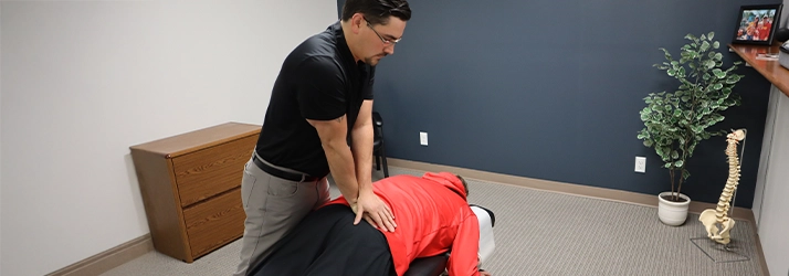 Chiropractor Leavenworth KS Dennis Lindsay Adjusting Patients Lower Back