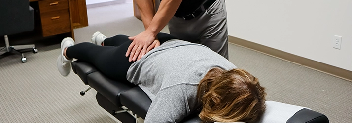 Chiropractor Leavenworth KS Dennis Lindsay Adjusting Patients Sciatic Area