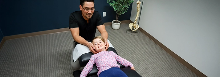 Chiropractor Leavenworth KS Dennis Lindsay Adjusting Pediatric Patient